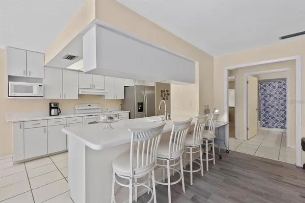 a kitchen with stainless steel appliances a table and chairs in it
