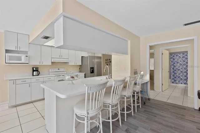 a kitchen with stainless steel appliances a table and chairs in it