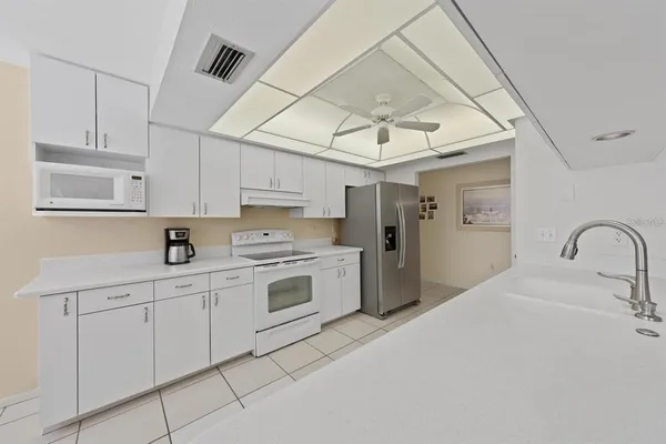 a kitchen with white cabinets and white appliances