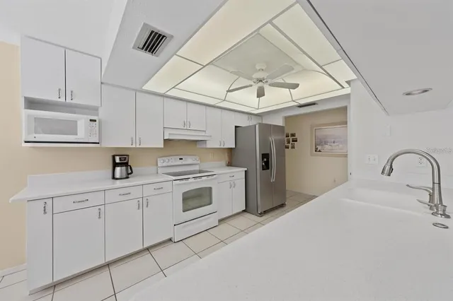 a kitchen with white cabinets and white appliances