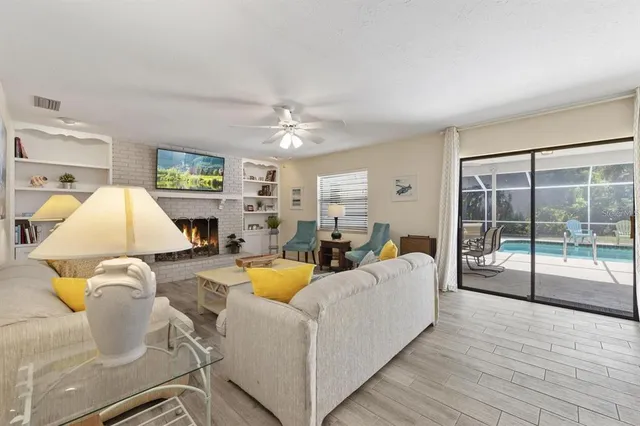 a living room with furniture a flat screen tv and a floor to ceiling window