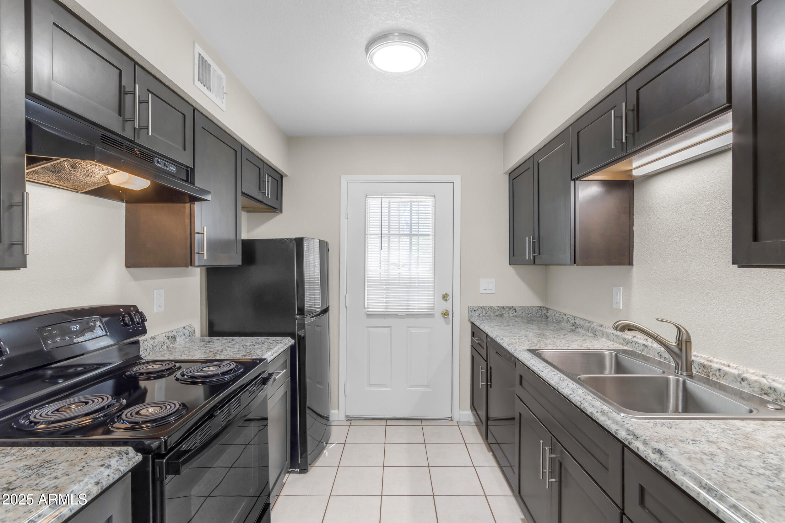 834 North Cherry, Unit 102 Mesa, AZ 85201 - Photo 12 of 24 a kitchen with stainless steel appliances granite countertop a sink stove and refrigerator