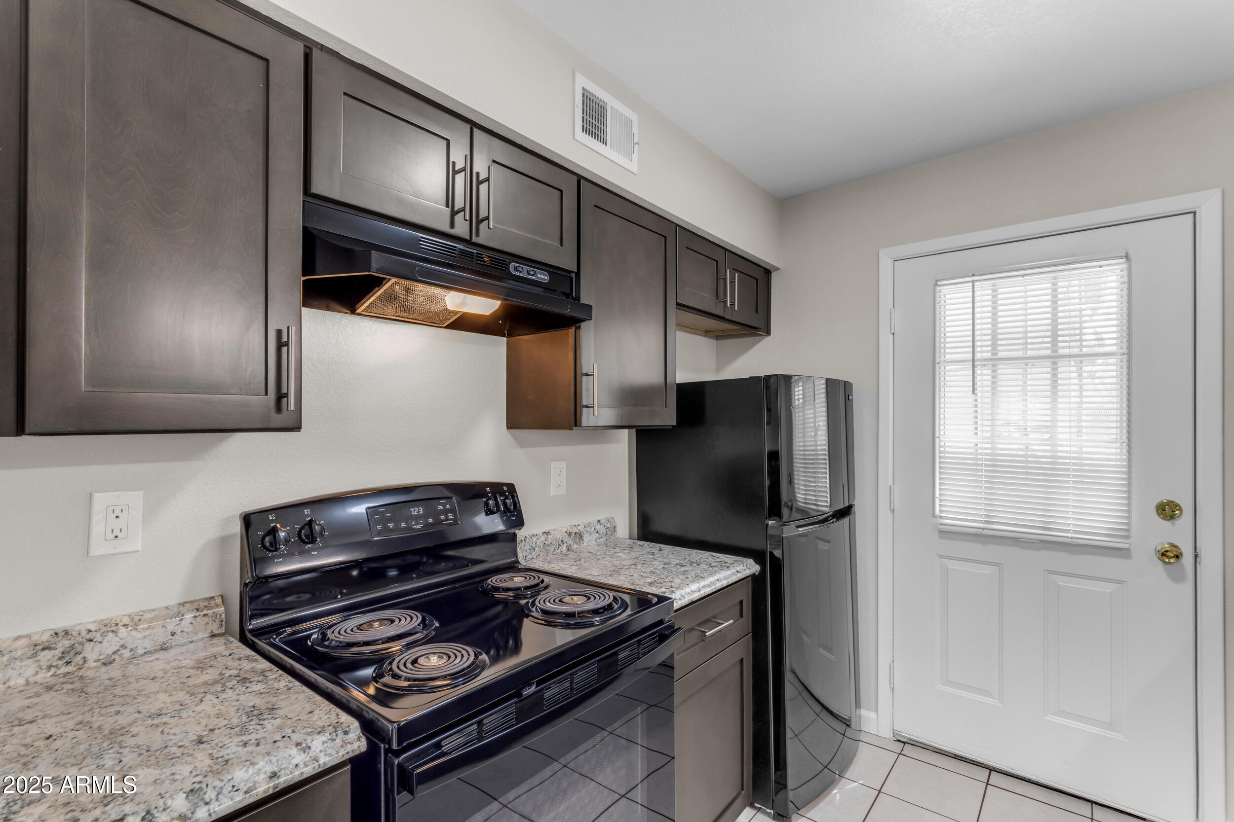 834 North Cherry, Unit 102 Mesa, AZ 85201 - Photo 15 of 24 a kitchen with stainless steel appliances granite countertop a stove refrigerator and microwave
