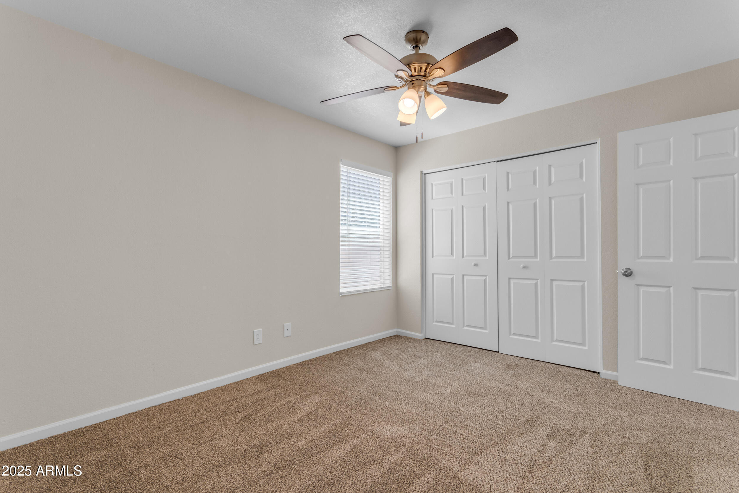 834 North Cherry, Unit 102 Mesa, AZ 85201 - Photo 18 of 24 an empty room with a chandelier fan and windows