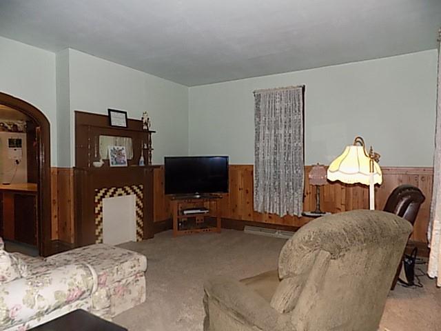 413 Lowell Street Vandergrift, PA 15690 - Photo 2 of 8 a living room with furniture a flat screen tv and a refrigerator
