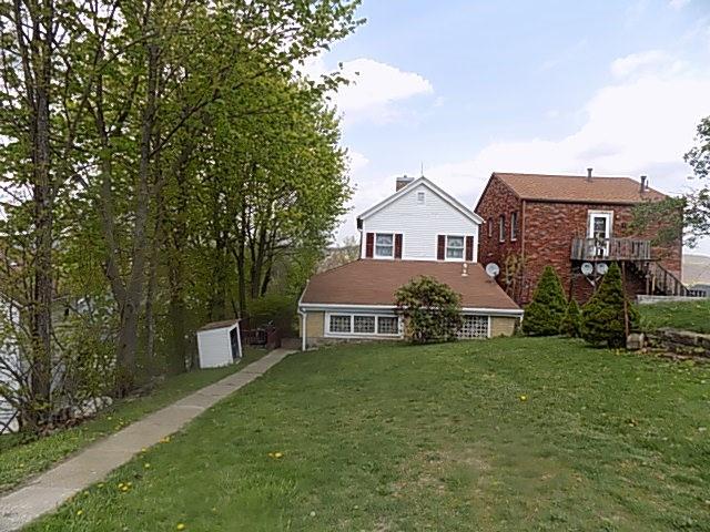 413 Lowell Street Vandergrift, PA 15690 - Photo 6 of 8 a front view of a house with a yard and garage