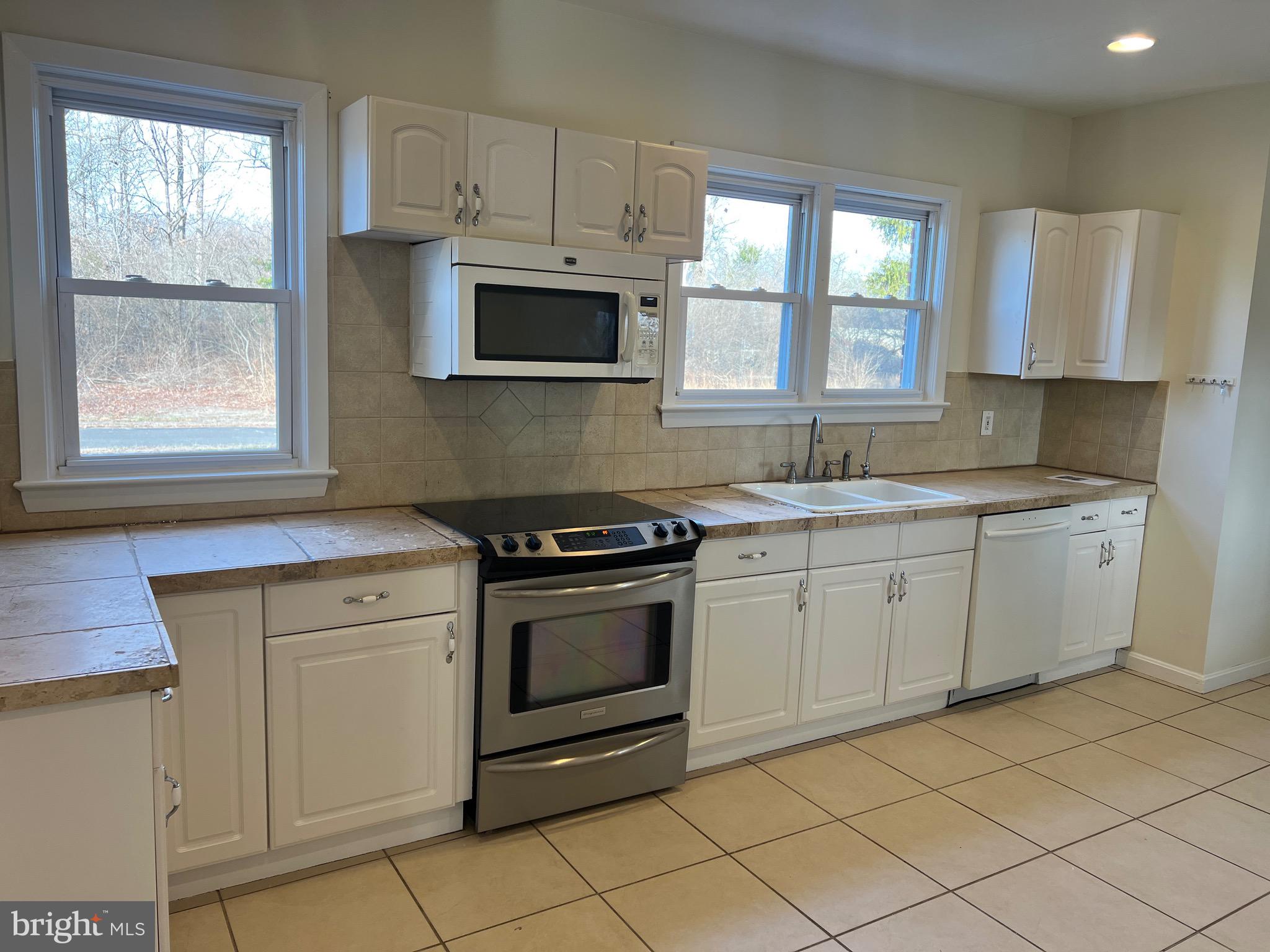 231 Highway 73 Hammonton, NJ 08037 - Photo 7 of 20 a kitchen with white cabinets appliances and a window