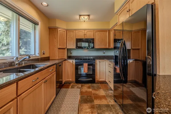 a kitchen with stainless steel appliances granite countertop a refrigerator and a sink