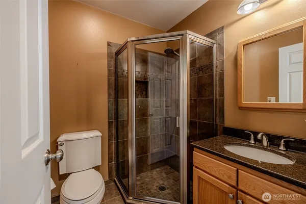 a bathroom with a granite countertop sink toilet and shower