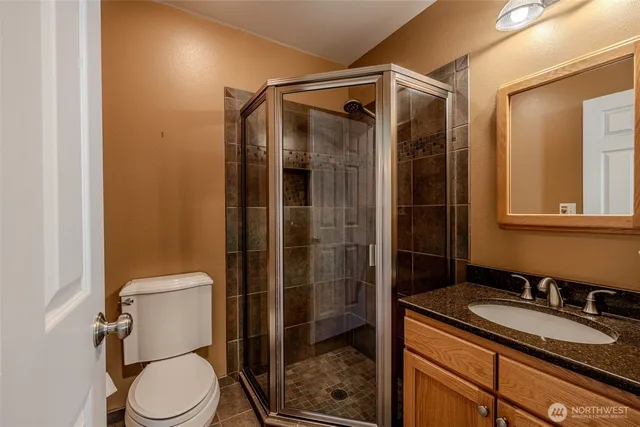 a bathroom with a granite countertop sink toilet and shower