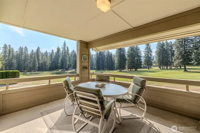 a view of a swimming pool with a table and chairs in patio