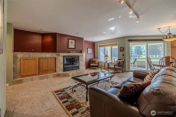 a living room with furniture a large window and a fireplace