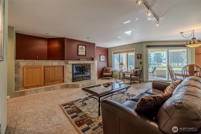 a living room with furniture a large window and a fireplace