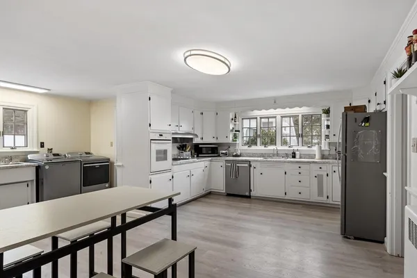 a kitchen with granite countertop white cabinets and stainless steel appliances