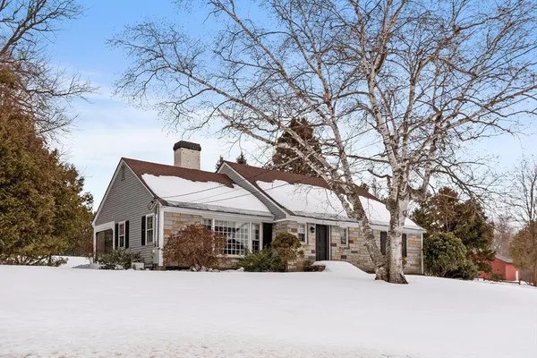 a front view of a house with a yard covered in snow