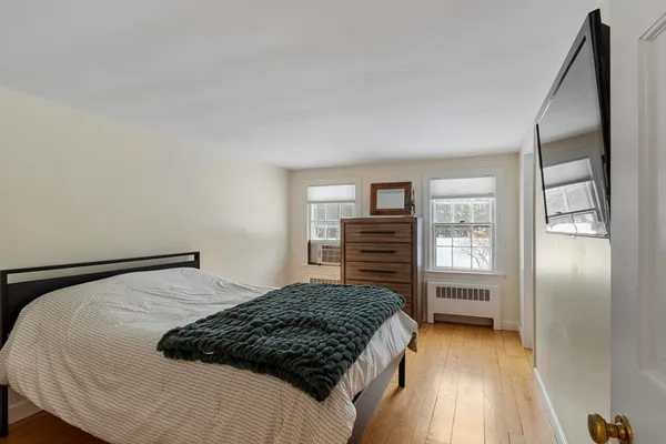 a bedroom with a bed next to a window