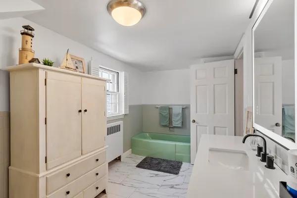 a bathroom with a tub sink and mirror