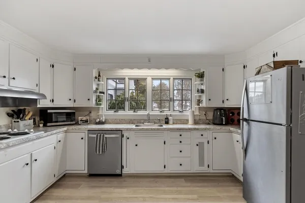 a kitchen with a sink a window and stainless steel appliances