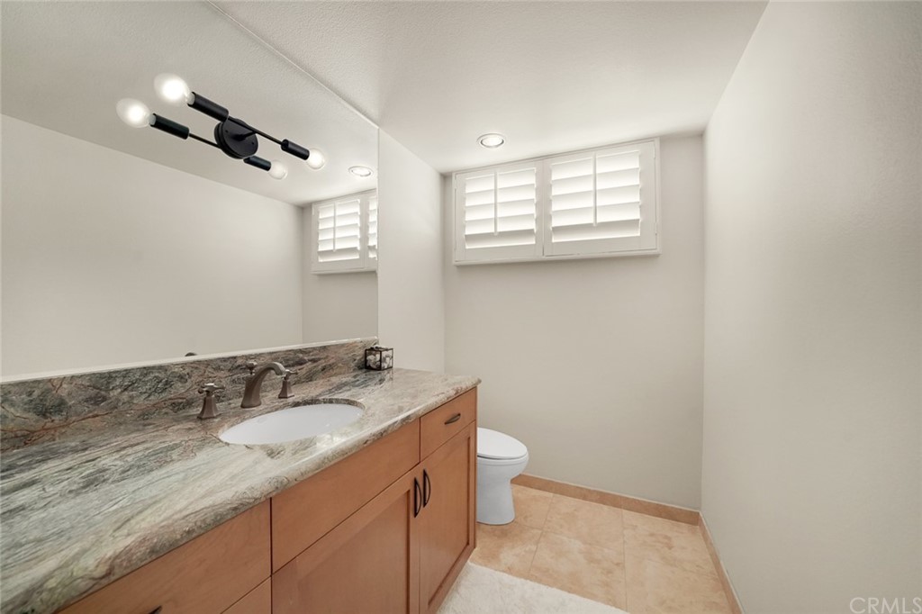 37 Emerald Bay Laguna Beach, CA 92651 - Photo 38 of 52 a bathroom with a granite countertop sink a toilet and a mirror