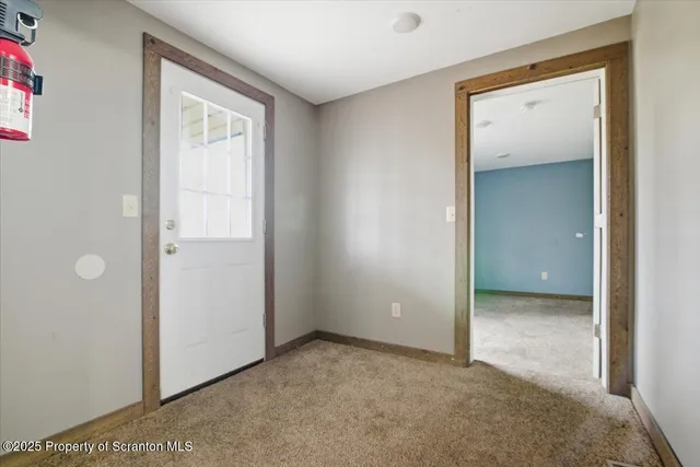 a view of an empty room with closet and a bathroom