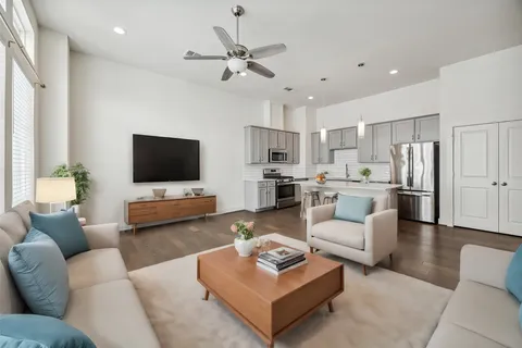 a living room with furniture kitchen view and a flat screen tv