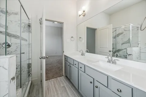 a bathroom with a double vanity sink a mirror and shower