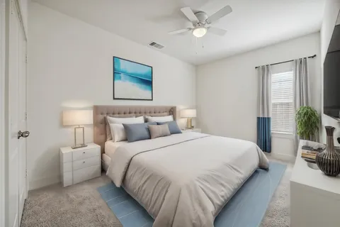 a bedroom with a bed and a potted plant