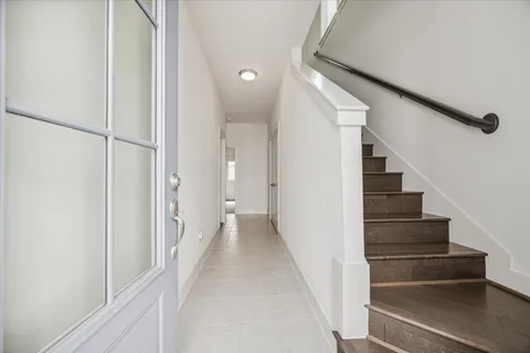 a view of a hallway with wooden floor and entryway