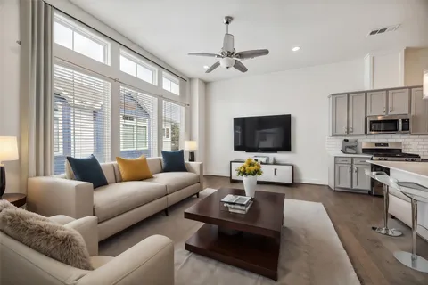 a living room with furniture a flat screen tv and a large window