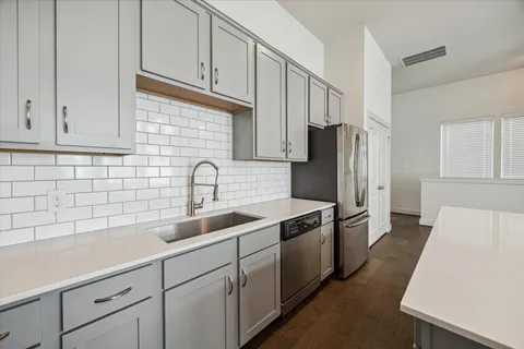 a kitchen with stainless steel appliances a refrigerator sink and cabinets