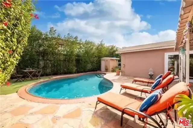 a view of backyard with swimming pool and outdoor seating
