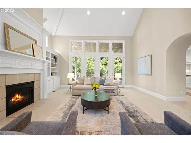 a living room with furniture a fireplace and a large window