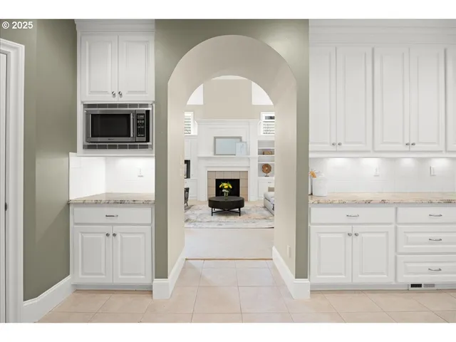 a kitchen with granite countertop white cabinets and window