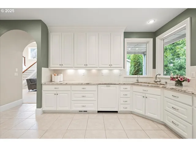 a kitchen with granite countertop white cabinets and white appliances