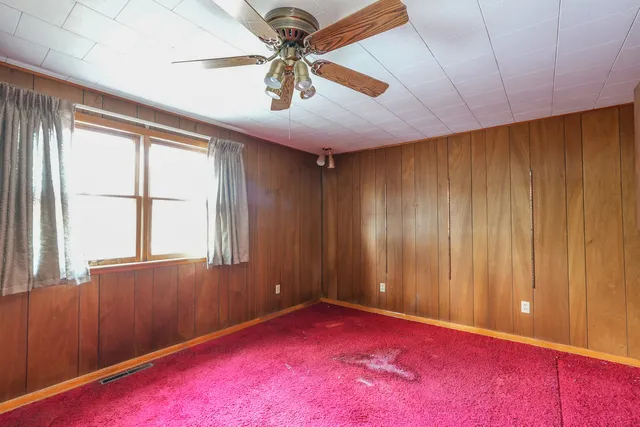 an empty room with fan and windows