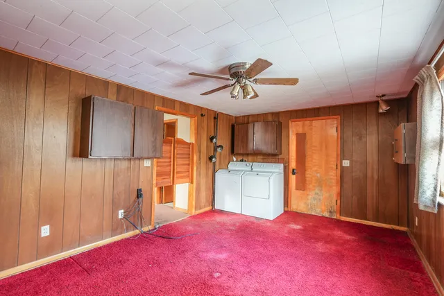 a view of an empty room with window and cabinet