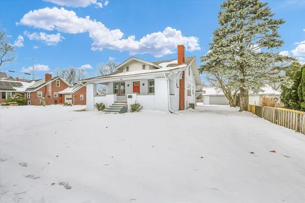 a view of house with outdoor space and view of small house