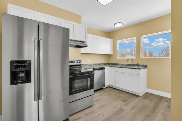 a kitchen with granite countertop a sink and steel appliances