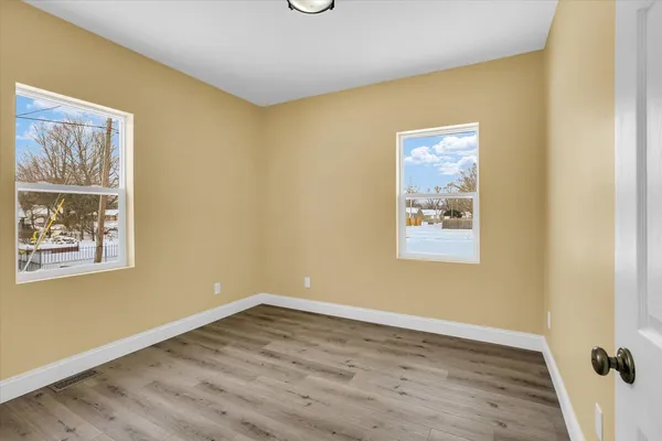 a view of an empty room with wooden floor