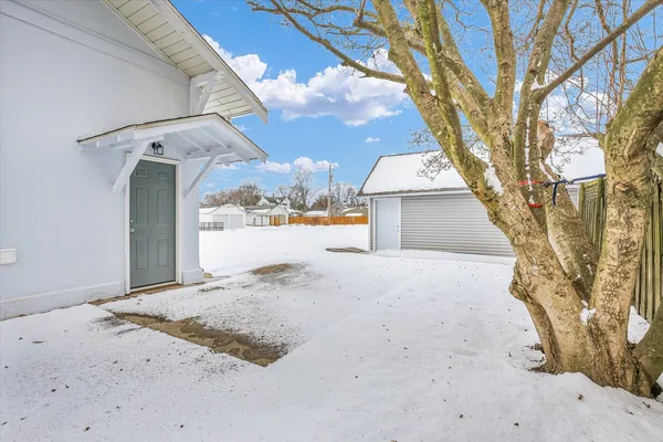 a view of white house with a snow in the yard