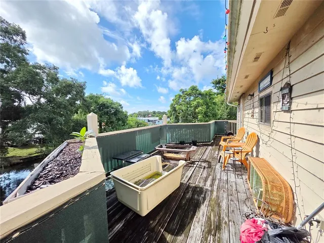 a roof deck with table and chairs and potted plants