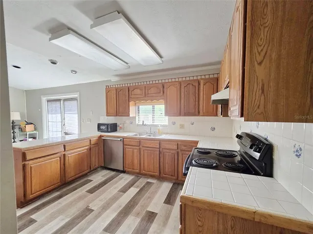 a kitchen with sink a stove and cabinets