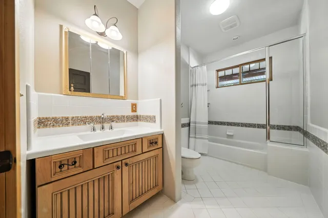 a bathroom with a granite countertop sink a mirror and a bathtub