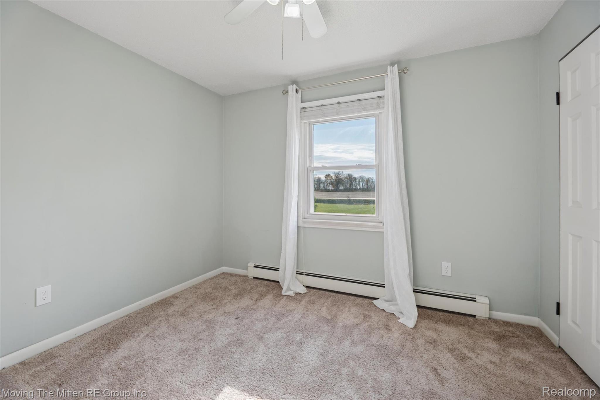 12000 Plank Road Milan, MI 48160 - Photo 26 of 49 Unfurnished room featuring light carpet, baseboard heating, and a ceiling fan