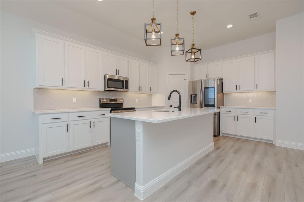 520 Mustang Lane Pilot Point, TX 76258 - Photo 5 of 15 a kitchen with a sink stainless steel appliances and white cabinets