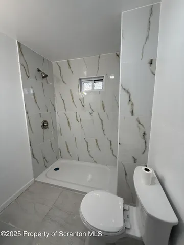 a bathroom with a toilet a sink and shower