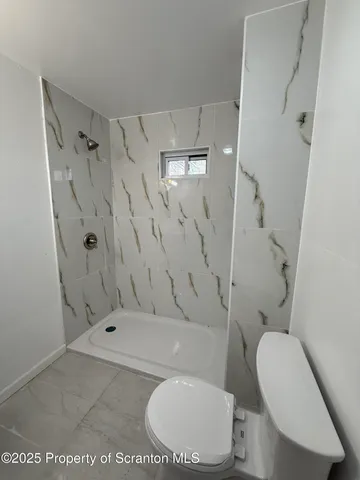 a bathroom with a toilet and a shower