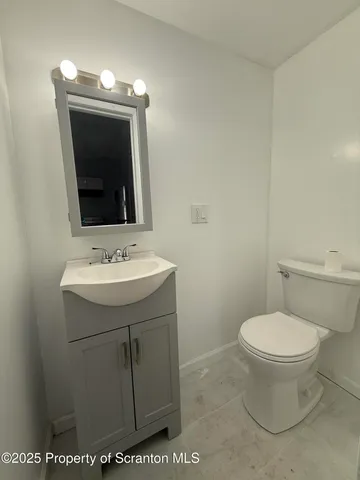 a bathroom with a sink toilet and mirror