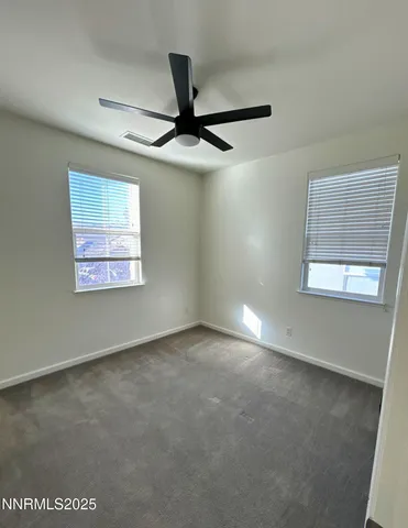 an empty room with a ceiling fan and a window