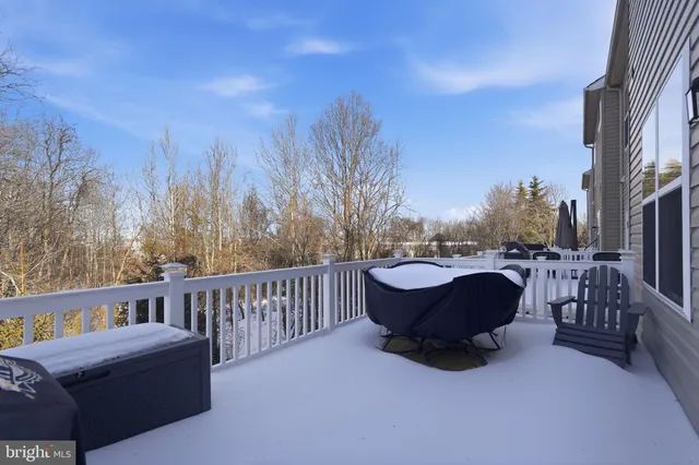 a view of a roof deck with couches and wooden fence